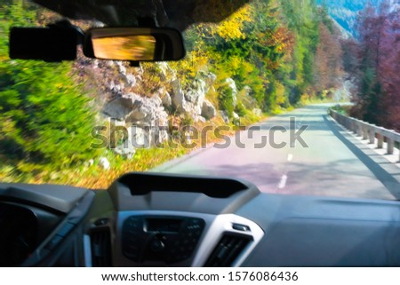 Driving car down the mountains with a caption view of the road taken through the wind shield