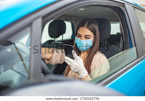 Driving car with face mask.
Young woman driving car with protective mask on her face.
Healthcare, virus protection, allergy protection concept. Driving
car with face mask