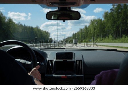 Driving car inside view. Man is holding steering wheel on highway