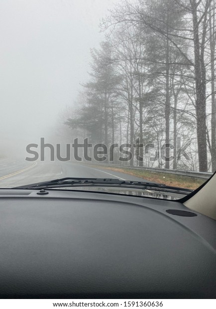 Driving a car in a mist/\
foggy road