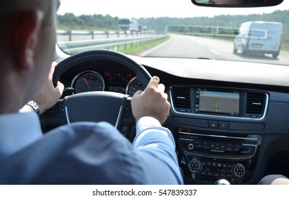 Driving a car on a highway with other vehicles blurred in front of him