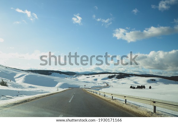 Driving a car on\
mountain in winter day. View from a car passenger view. Driving a\
car on mountain road. 