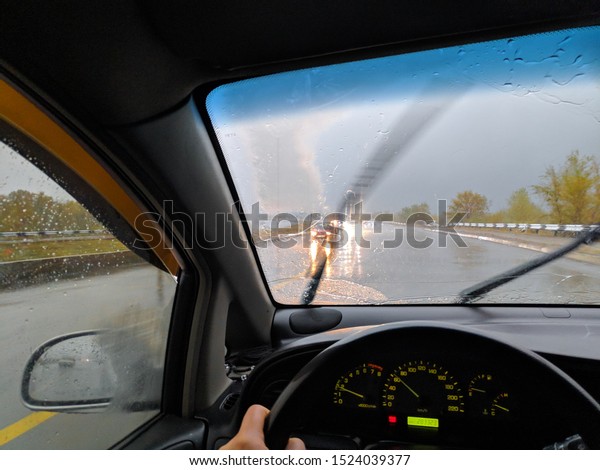 driving\
a car in the rain. rain and bad weather. wet\
road