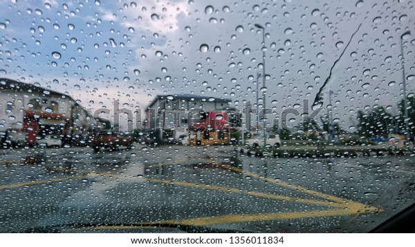 Driving car in the rain on wet road. Rainy
weather through the car window. Rain through wind-screen of moving
car. View through the car window in the
rain.