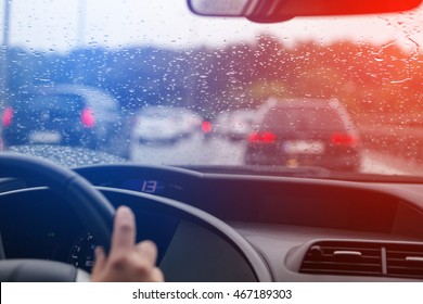 Driving a car in traffic jam in bad weather conditions, blue and red police lights