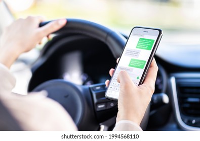 Driving Car And Using Phone. Distracted Driver Texting With Mobile Cellphone. Irresponsible Woman Checking Sms Message With Smartphone In Traffic. Auto Accident Concept. Holding Smart Device In Hand.