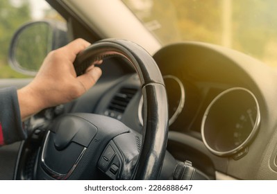 Driving with a car . View from car inside. Steering wheel with man hand