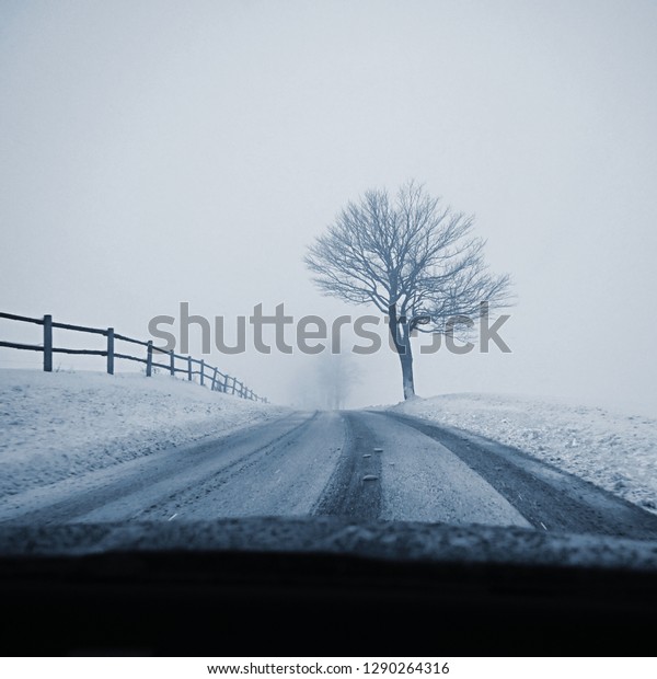 Driving the car in the winter. View from the\
interior of a car on a snowy road by the eyes of the driver.\
Concept for driving safety in the\
winter.