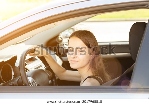 driving courses,student driver in a driving\
school at a driving lesson behind the wheel of a car,girl gets a\
driver\'s license