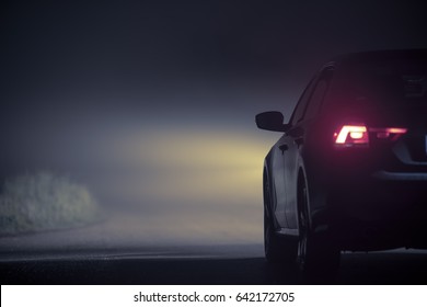 Driving In Dense Fog At Night. Modern Car On The Foggy Road During Night Hours. Foggy Highway Conditions.