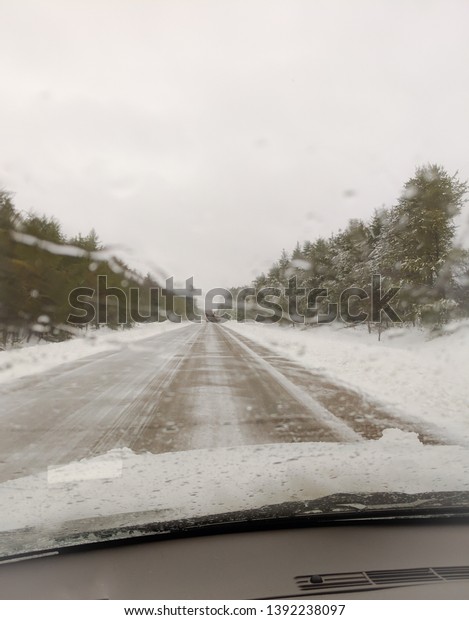 Driving\
during winter snow storm. Snow covered\
road