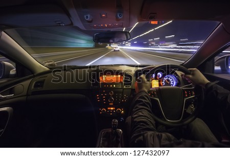Driving fast after a car on motorway at night.
