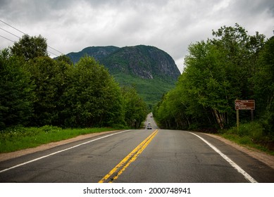 Driving up to the Grands-Jardins National park entrance, with the road in the middle of the image and large mountain in the background