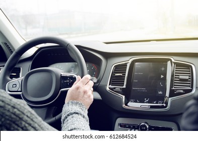 Driving Hybrid New Luxury Suv Car Inside Cockpit View With Sun Glare On The Windshield And Dashboard With Big Tablet Touch Screen In The Middle