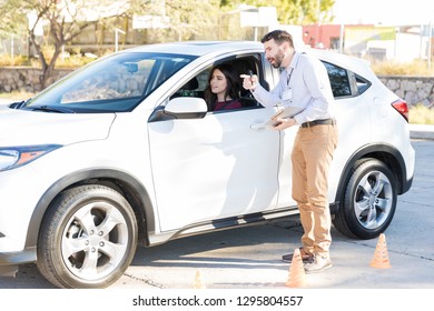 Driving Instructor Explaining Directions To Woman During Driving Class