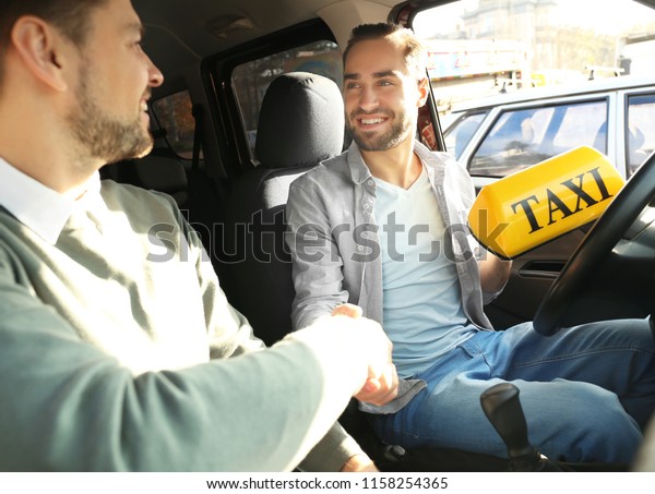 Driving
instructor giving taxi sign to trainee in
car