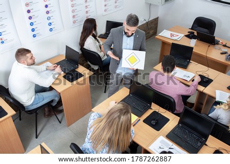 Driving instructor introducing his students to traffic signs while training them