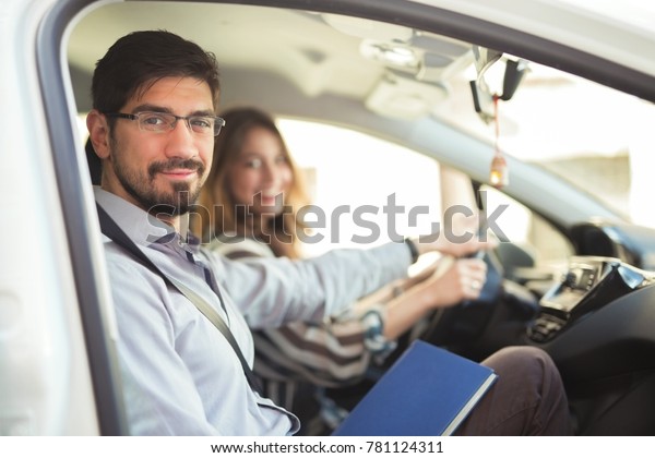 Driving instructor is teaching his student how to\
drive a car