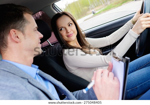Driving\
instructor and woman student in examination\
car
