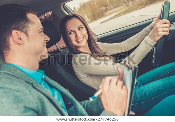 Driving\
instructor and woman student in examination\
car