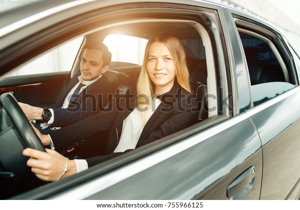 Driving\
instructor and woman student in examination\
car.