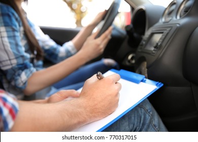 Driving instructor writing down results of exam, closeup