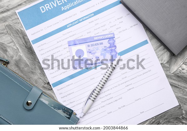Driving license with application form and\
wallet on grunge\
background