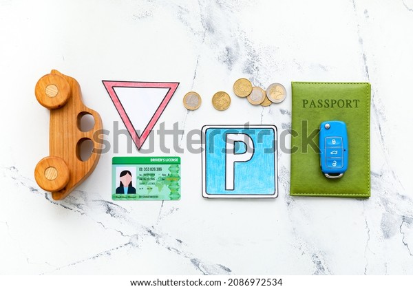 Driving license with car, key, passport and\
traffic signs on white\
background