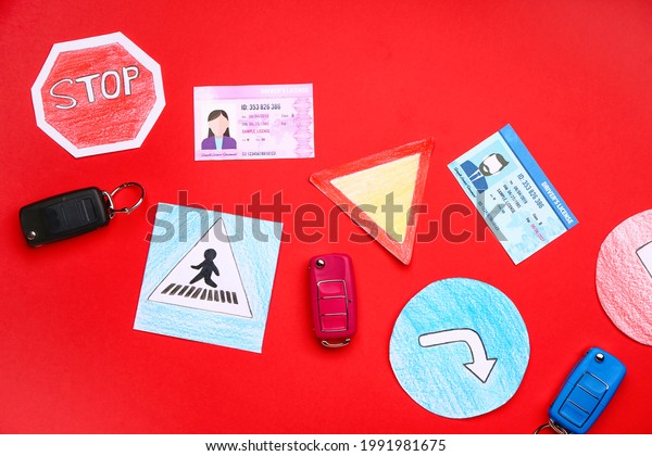 Driving license with car keys and road signs\
on color background