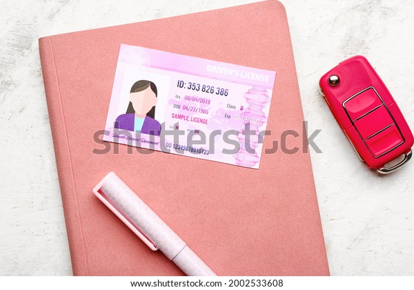 Driving license with notebook and car key on\
white background