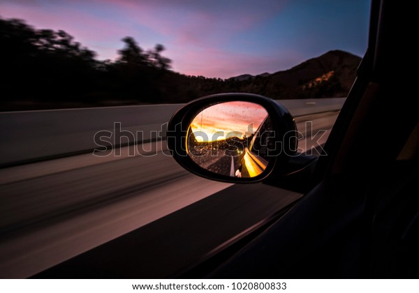 Driving in movement oval mirror car on highway
on a sunset landscape