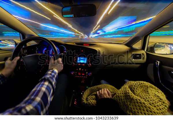 Driving in night scenery, hands on steering wheel,\
night rain time