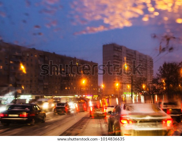 driving in night snowfall in Moscow -\
unfocused background with view of car traffic in Moscow city in\
snowy evening through wet\
windscreen