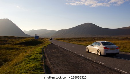 Driving on a road in the scottish highlands during sunset