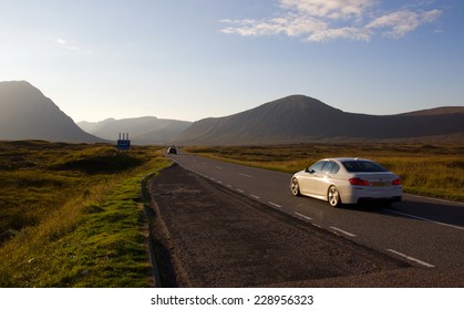 Driving on a road in the scottish highlands (Glencoe) during sunset - Powered by Shutterstock