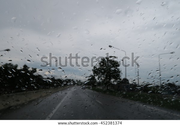 Driving on the street in the rain, Car windshield\
with rain drops.