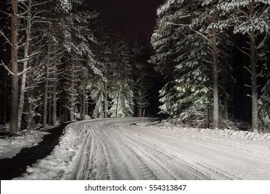 Driving On A Winter Road At Night, Snow And Ice Is Brightly Lit By The Head Lights.