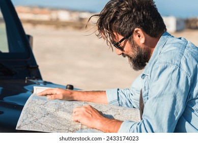 Driving problems. One man driver lost on the roads use paper old guide map to find destination. People and transport lifestyle adventure tourism. Summer country side desert in background. Journey - Powered by Shutterstock