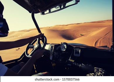 Driving quad buggy car at desert dunes at Al Awir near Dubai, inside vehicle view