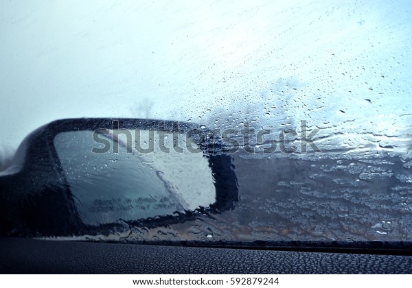 Driving in\
the Rain (rain on the window and\
mirror)