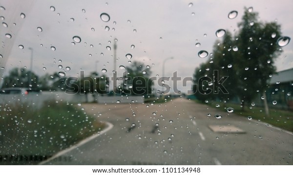 Driving\
in rain. Rainy weather through the car window.\
