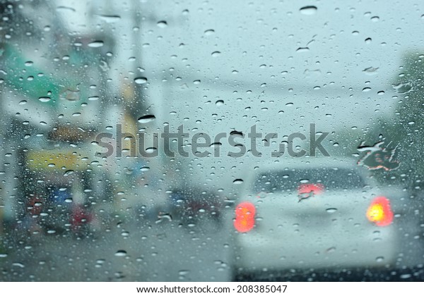 Driving in rain, Road view through car window with\
rain drops.