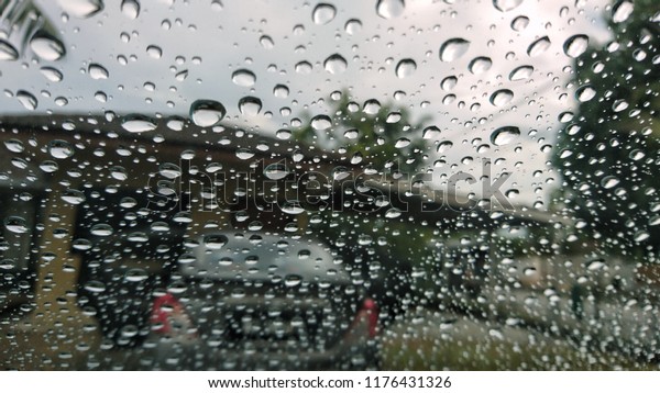 Driving in rain. Selective focus.\
Road view through car window with rain drops driving in rain.\
