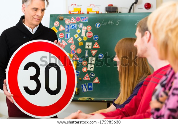 Driving\
school - driving instructor and student drivers with a tempo thirty\
Road sign, in the background are traffic\
signs