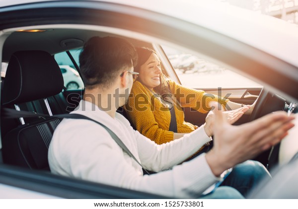 Driving school\
or test. Beautiful young pregnant woman learning how to drive car\
together with her instructor.\
