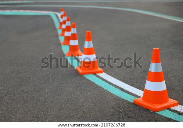 Driving school test track with marking lines, focus\
on traffic cone