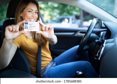 Driving school. Young beautiful woman successfully passed driving school test. Female smiling and holding driver's license. Girl with driving license. - Shutterstock ID 1785688385