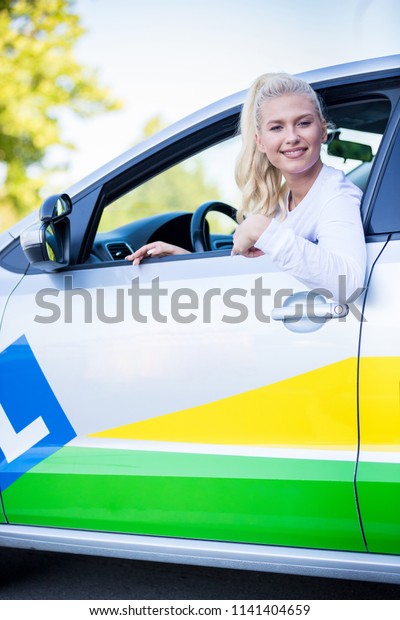 Driving school. Young happy woman -
student sitting in a car. Free space for text. Copy
space.