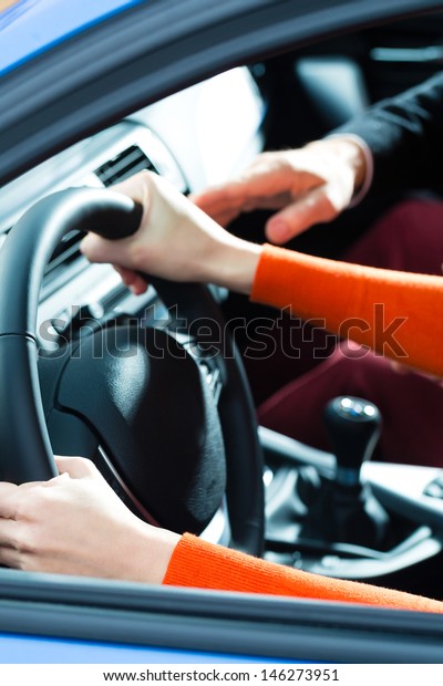 Driving School - Young woman steer a car with the\
steering wheel, maybe she has a driving test perhaps she exercises\
the parking