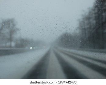 Driving in a snow storm. Poor visibility through the driver's glass onto the road covered with snow and ice. Winter, Blizzard.
